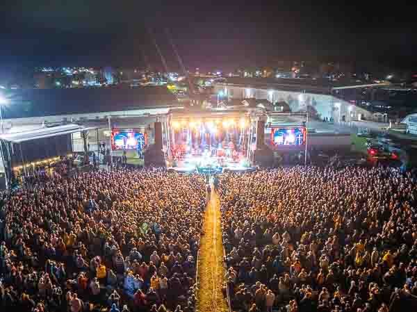 An aerial view of the vast Healing Appalachia crowd captivated by a nighttime performance.