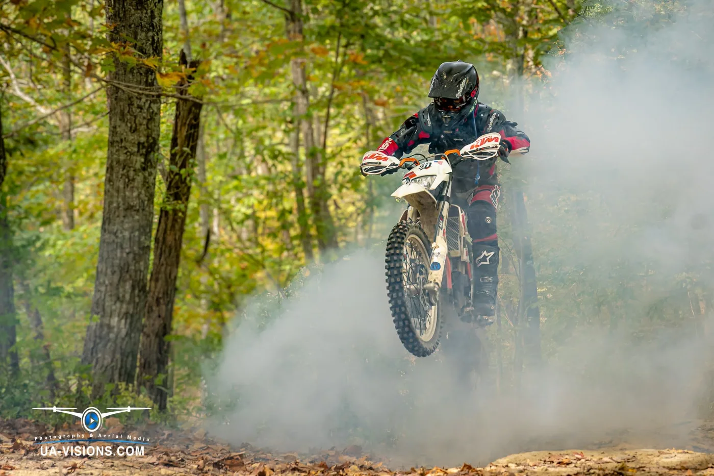Off-Road Mastery in West Virginia's Forest Trails Motocross rider traversing a dusty trail amidst the dense forests of West Virginia.