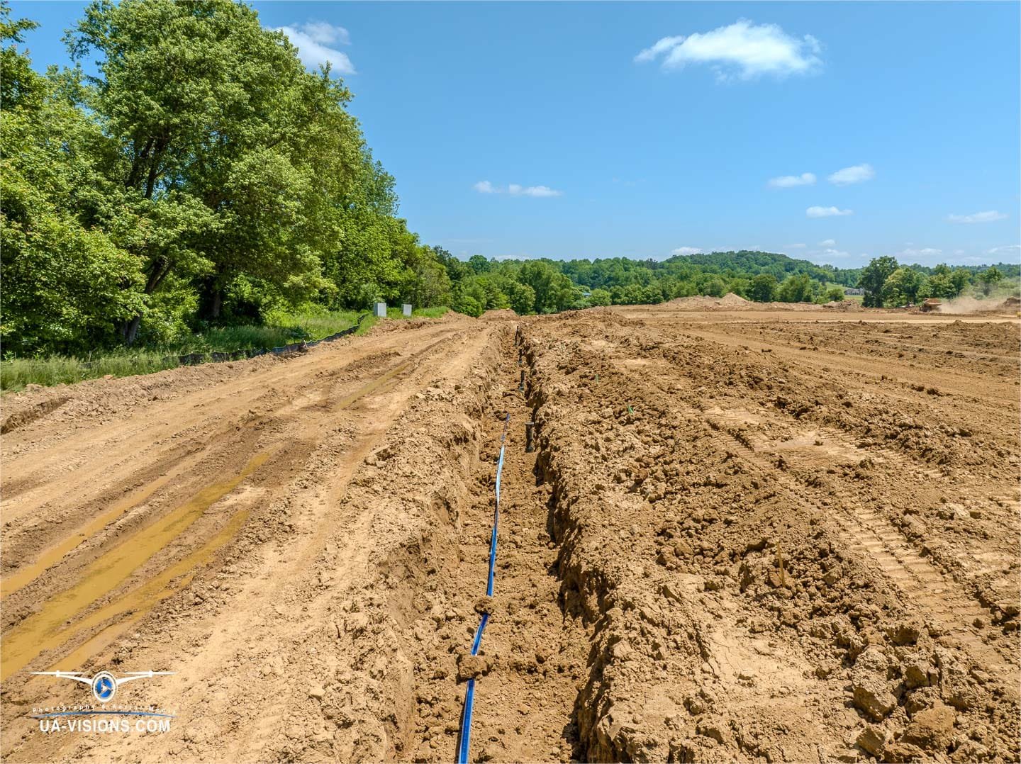 The blue line of progress snakes through SDRS's landscape, a contrasting ribbon captured by UA-Visions' hovering eye.