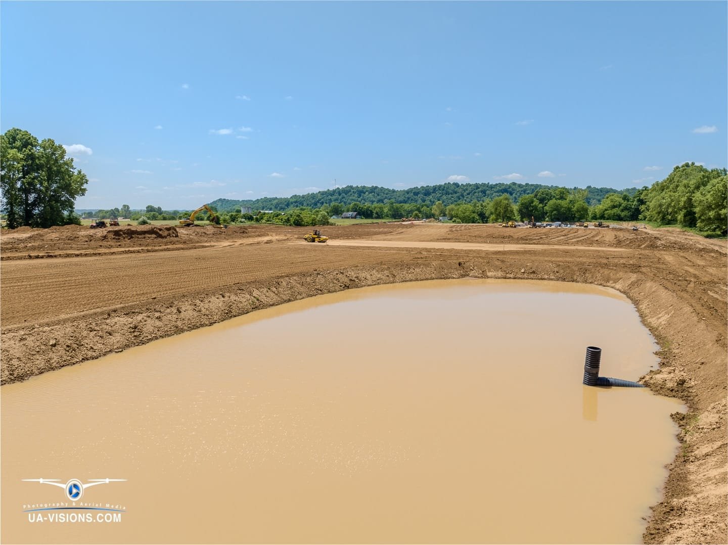 A tranquil pond offers reflective respite amidst SDRS's bustling site, a serene moment frozen by UA-Visions.