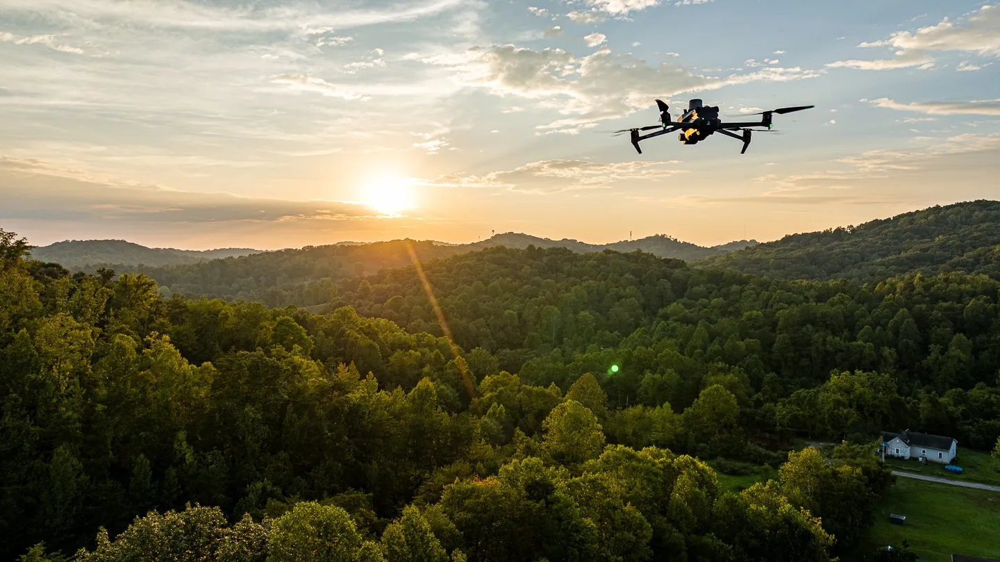 Sunset Aerial View by UA-Visions Drone Photos: Aerial drone capturing sunset over the lush greenery of West Virginia's hills, showcasing UA-Visions' aerial photography services.