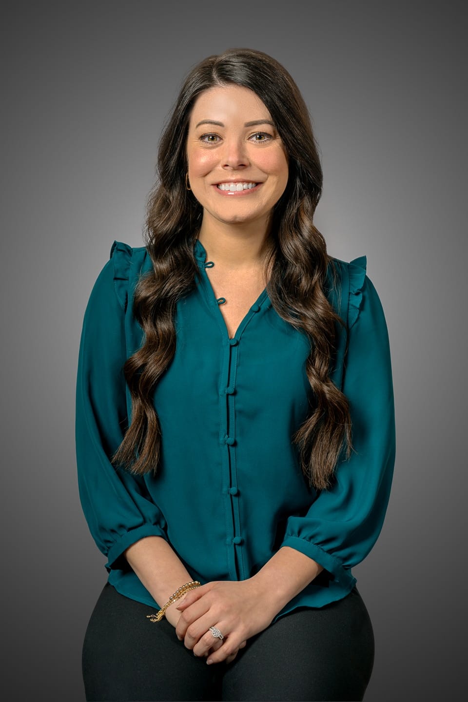 Professional headshot of a businesswoman with a friendly demeanor, wearing a teal blouse