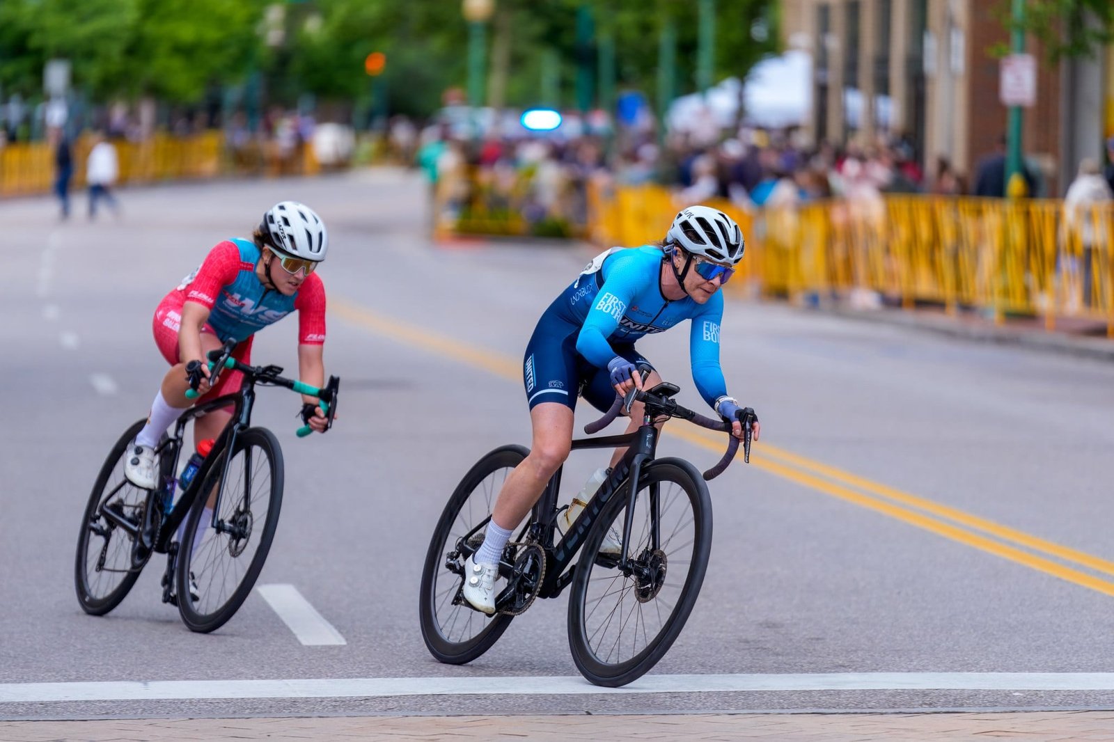 USA Cycling 2025 Photography and Video Two racing cyclists rounding a corner on a downtown course